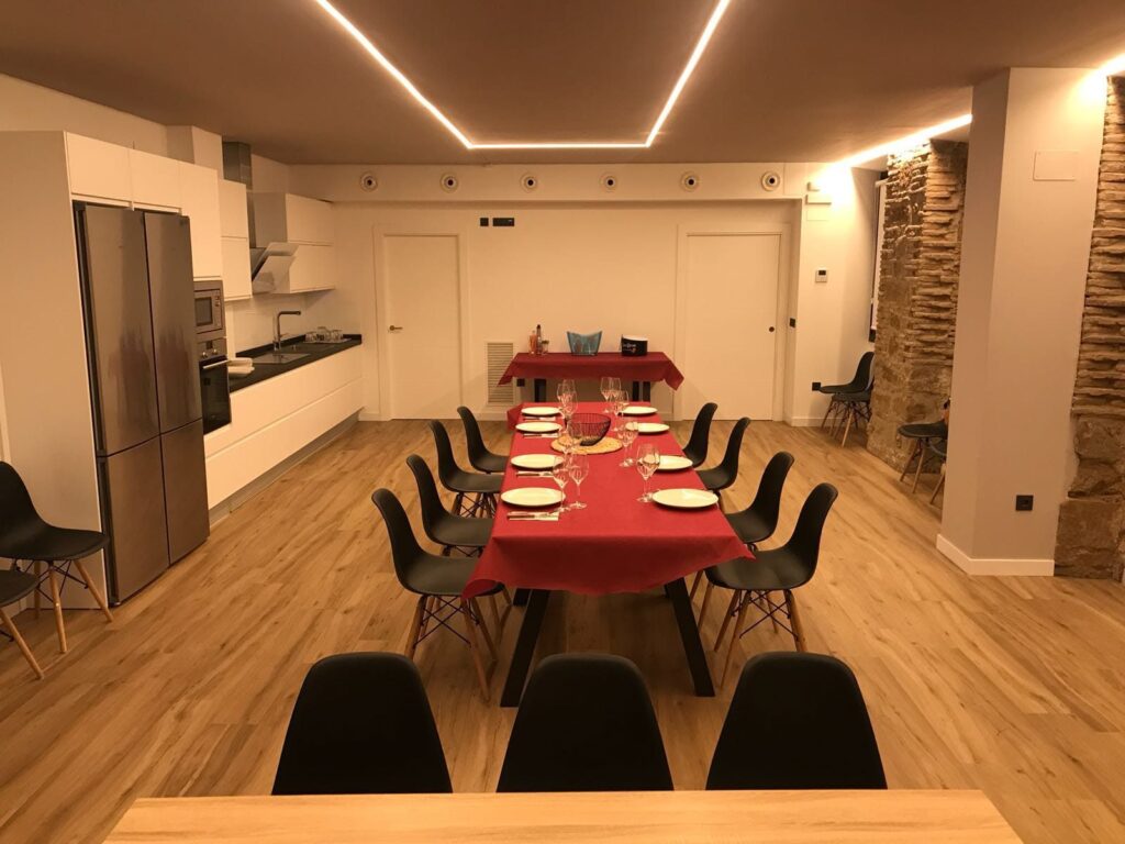 Sala con mesa preparada para una comida y cocina equipada